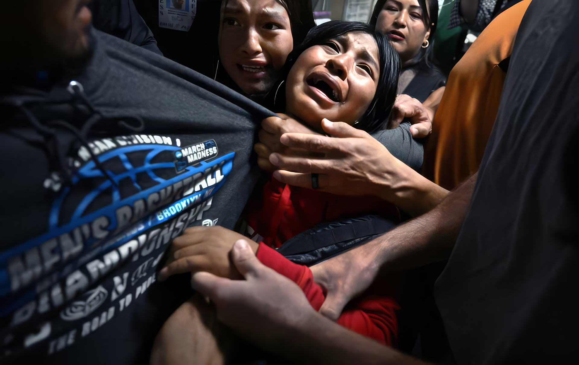 A woman crying while being held in a crowd during an immigration enforcement operation