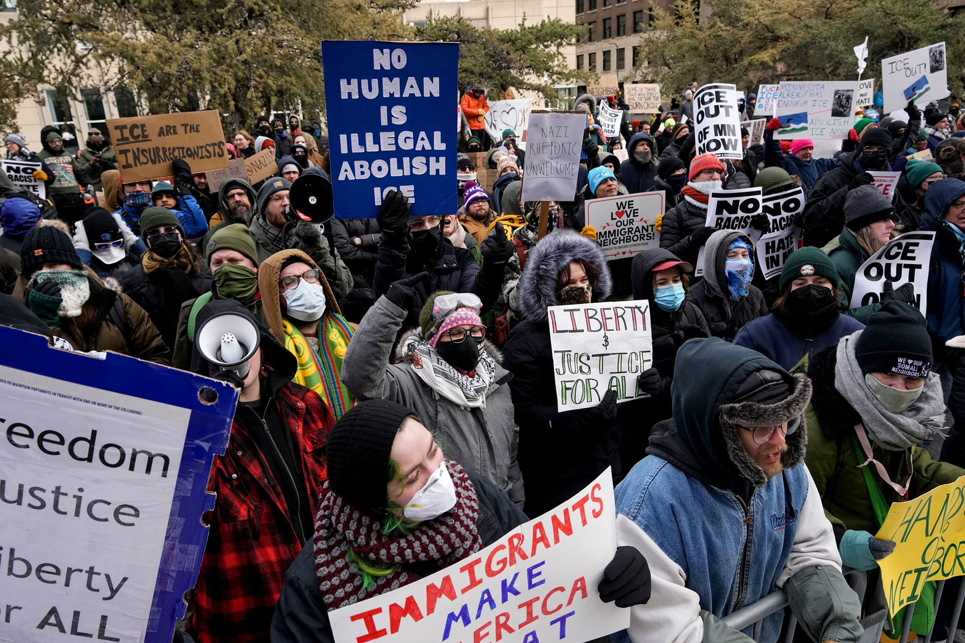 A large crowd protesting with signs demanding human rights and justice